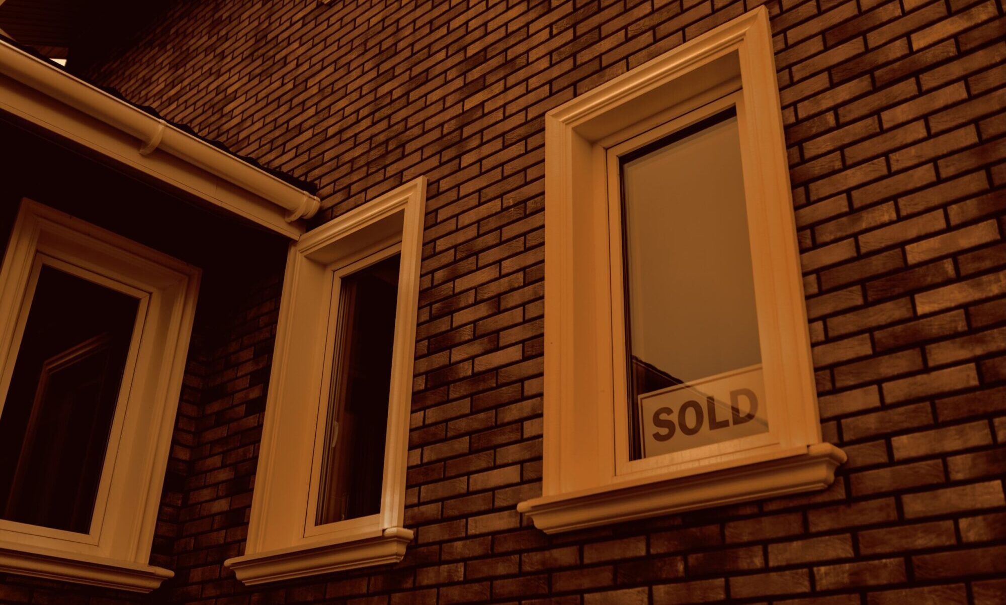 House with sold sign in the window